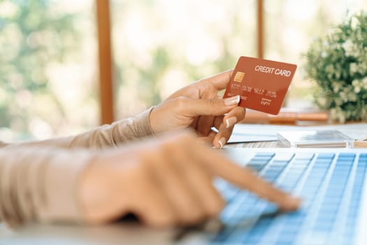 Close up credit card using for online payment, banking and shopping on the internet network with laptop computer showing credit card technology for online secured wallet top up and crucial purchase