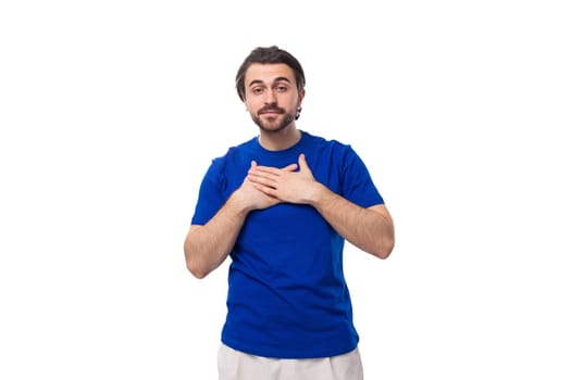 portrait of a young stylish caucasian brunette man with a beard in a blue t-shirt.