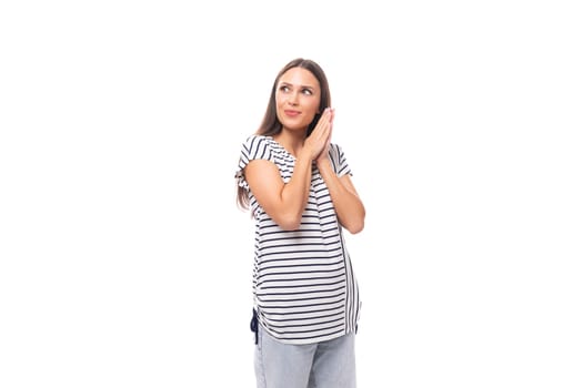 young european brunette woman in a striped sweater looks attentively to the side at copy space.