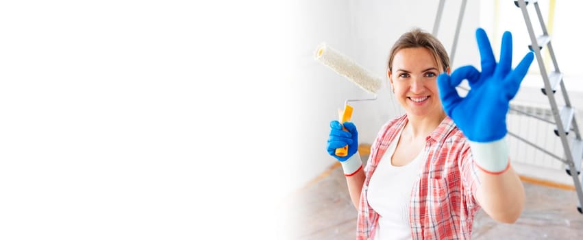Banner young smiling woman with roller brush showing ok gesture, copy space. Renovation, repair and redecoration concept