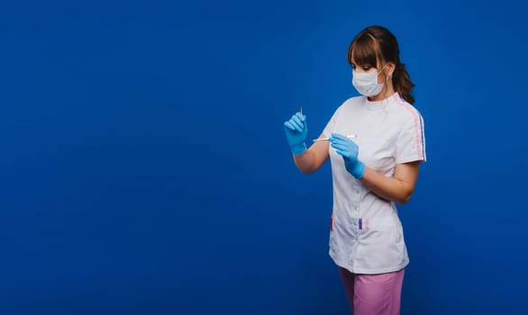 a female surgeon doctor holds a scalpel on a blue background.