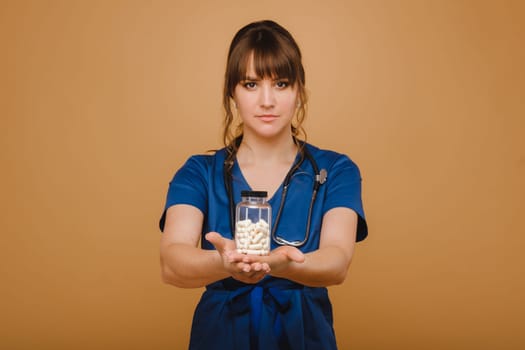 white pills in a jar of a female doctor. The doctor shows the vitamin capsules.Medicinal capsules