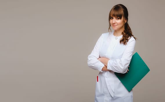 a female doctor with a notebook in her hands on a gray background.