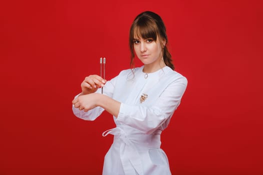 Beautiful girl doctor with a tuning fork stands.