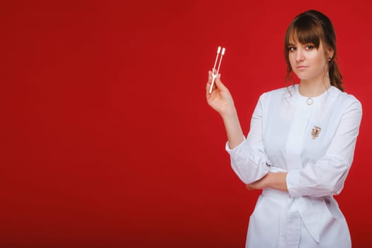 Beautiful girl doctor with a tuning fork stands.