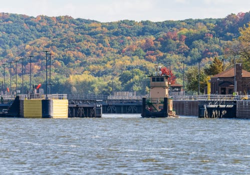 Tugboat pusher leaving Lock and Dam no. 12 on Upper Mississippi near Hannibal Missouri in the fall