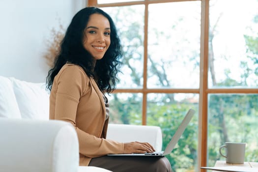 African-American woman using laptop computer for crucial work on internet. Secretary or online content writing working at home.