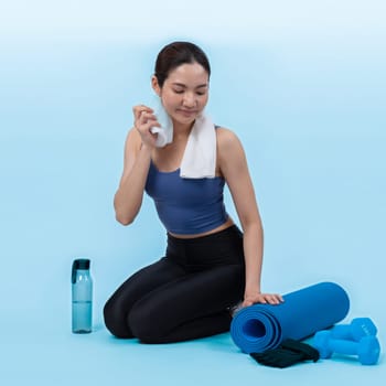 Athletic and sporty asian woman resting after intensive cardio workout training. Healthy exercising and fit body care lifestyle pursuit in studio shot isolated background. Vigorous