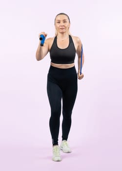 Full body length shot athletic and sporty senior woman with fitness exercising rope on isolated background. Healthy active physique and body care lifestyle senior people. Clout