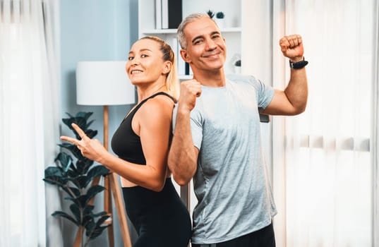 Athletic and sporty senior couple portrait in sportswear with successful or celebrating after overcome struggle posture as home exercise concept with healthy fit body lifestyle after retirement. Clout