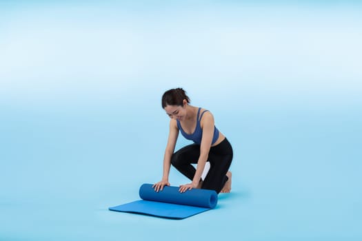 Young attractive asian woman portrait in sportswear with exercising mat. Healthy exercise and workout routine lifestyle concept. Studio shot isolated background. Vigorous