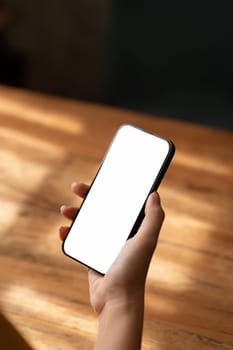 Mockup, woman's hand holding using mobile phone at coffee shop with copy space, white blank screen for text, mobile app design and advertising, online marketing.