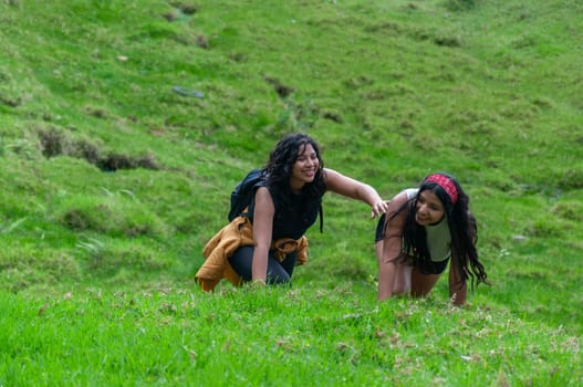 two young friends joking around on their summer vacation on a mountain with lots of vegetation on a mountain in ecuador, latin america. High quality photo