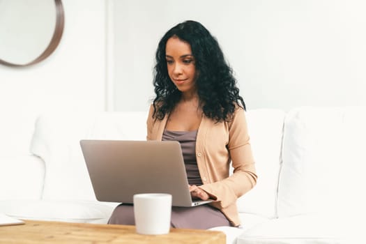 African-American woman using laptop computer for crucial work on internet. Secretary or online content writing working at home.