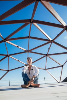 fashionable woman posing by wooden structure