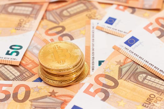 A Stack of Bitcoin Coins on the 50 Euro Banknotes. Euro Currency and Crypto Currency. Orange Paper Money. A Lot of Fifty-Euro Bills. Finances, Cash, Anonymous Payments and Money Saving Concept