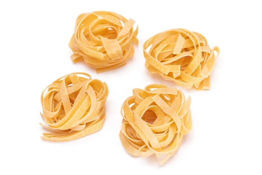 Four Classic Italian Raw Egg Fettuccine - Isolated on White Background. Dry Twisted Uncooked Pasta. Italian Culture and Cuisine. Raw Golden Macaroni Pattern - Isolation