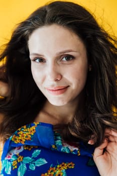 Portrait of a brunette woman on a yellow background