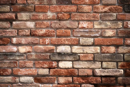 Texture of an old brick wall. Old red brick clay wall with on a sunny day. Clay brick walls of Italy.