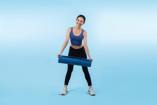 Young attractive asian woman portrait in sportswear with exercising mat. Healthy exercise and workout routine lifestyle concept. Studio shot isolated background. Vigorous