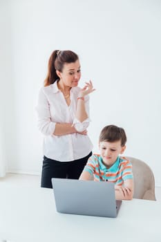 Mom helps her son do school assignment on computer