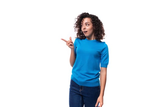 a bright curly woman dressed in a blue summer jacket actively gesticulates against the background with copy space. advertising concept.