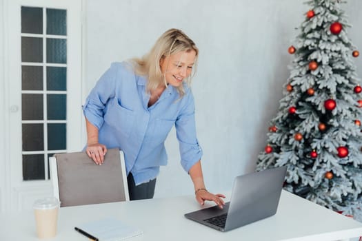 Woman working at computer at christmas tree white