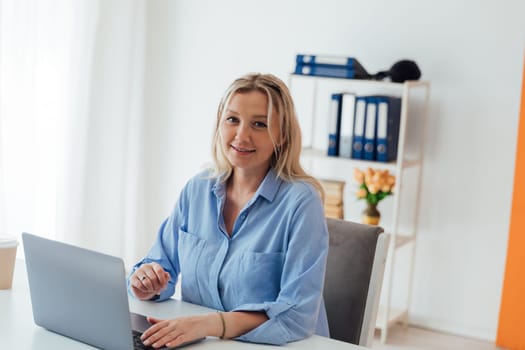 Business woman working on laptop at desk in office at home