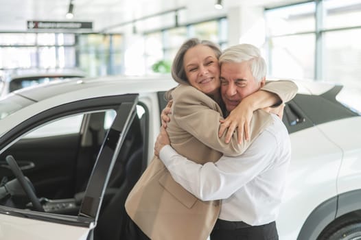 Mature Caucasian couple hugging. Elderly man and woman buying a new car