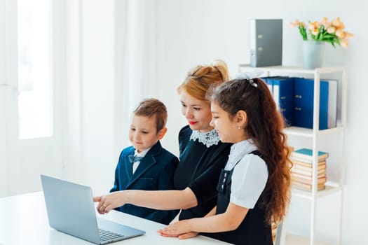 Female teacher teaching kids to work on computer online