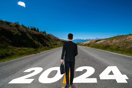 2024 New Year journey and future vision concept . Businessman traveling on highway road leading forward to happy new year celebration in beginning of 2024 for bliss and successful start .