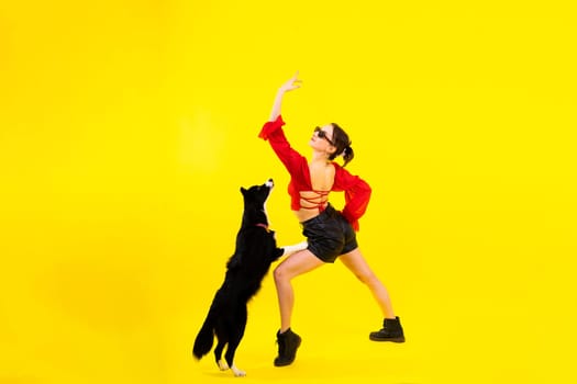 Cute young woman kisses and hugs a puppy border collie dog. Love between owner and dog.