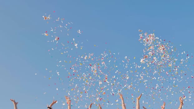 Tossing colorful paper confetti from the hands of young people