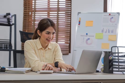 Business woman using calculator and laptop for do math finance on wooden desk in office and business working background, tax, accounting, statistics and analytic research concept.