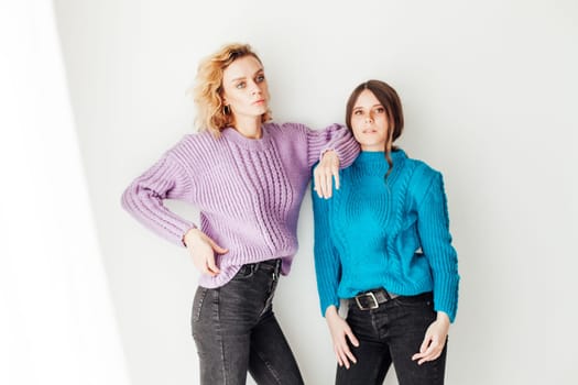 Two female girlfriends posing on white