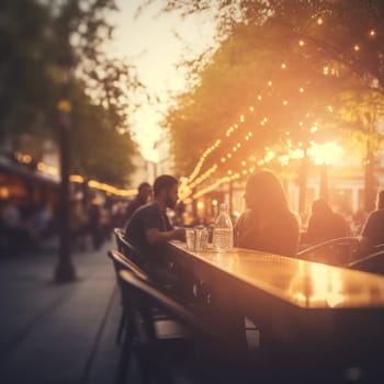 Blurred image of a street cafe or bar in the light of evening lights. In summer people sit at cafe tables.