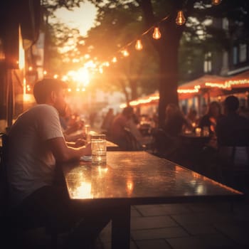 Blurred image of a street cafe or bar in the light of evening lights. In summer people sit at cafe tables.