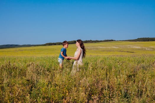 Mother and son walking in the nature of a field