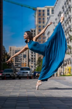 Beautiful Asian ballerina dancing outdoors. Urban landscape