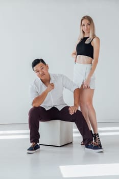 A man and a woman couple in love posing in a bright room