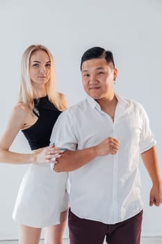 A man and a woman couple in love posing in a bright room