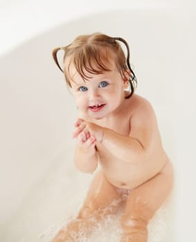 Portrait, cleaning and water with a baby girl in the bath for childhood hygiene or natural skincare. Children, bathroom and a happy young toddler in a bathtub for health and wellness in her home.