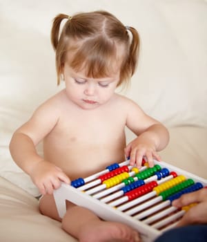 Learning, child development and a girl baby with an abacus in the bedroom of a home for growth. Kids, education or math with an adorable and curious young toddler counting on a bed in an apartment.