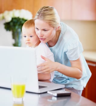Woman, baby and laptop for showing in home for learning, playing on streaming online. Mother, little boy or love in bond for growth, development or milestone with skills for technology in kitchen.