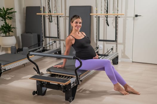 Pregnant woman resting after Pilates on a reformer machine
