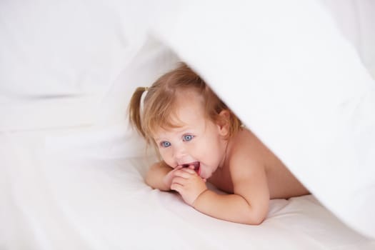 Home, growth and child development with a baby in the bedroom to relax alone in the morning. Happy, kids or youth and an adorable young infant girl on a bed with blankets for comfort in an apartment.