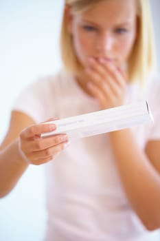 Anxiety, shock and woman with pregnancy test in bathroom waiting for results, news and surprise. Motherhood, pregnant and worried person with medical testing kit for fertility or ovulation at home.