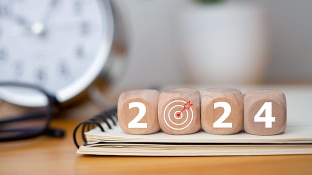 Wooden blocks with letters 2024 with calendar and alarm clock on wooden background representing the transition to 2024, Business Startup plan, The countdown begins to 2024, defining the future calendar strategy.