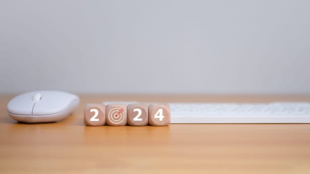 Wooden blocks line the wooden floor and bear the letters 2024, representing the setting of goals for 2024, the idea of a startup. Financial planning, development, business strategy Setting business goals