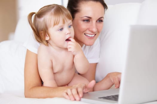 Family, laptop for remote work with a mother and baby in the bedroom of a home together to multitask. Computer, freelance or childcare with a woman parent and her girl toddler on an apartment bed.